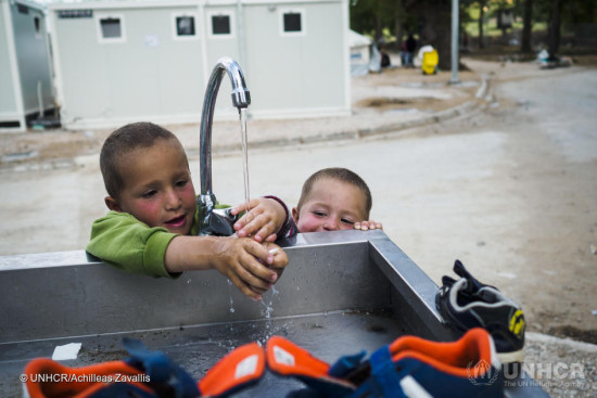 Two young brothers from Syria play with water at a WASH (Water, Sanitation and Hygiene) spot inside the new accommodation site at Lagkadikia. ; At least 10,000 refugees and migrants remain camped at the Idomeni site, at Greece’s northern border with the Former Yugoslav Republic of Macedonia, after nations along the so-called Western Balkan Route effectively closed their borders in March. Living conditions for those who remain at Idomeni are dire.   Greek authorities are gradually moving people from the informal site near Greece’s border village of Idomeni, to newly built, longer-term reception facilities throughout the country. From there, they can pursue legal options, such as applying for asylum in Greece or the European Union’s relocation scheme.   Far away from the unrest and despair of Idomeni, the Lagkadikia accommodation site offers refugee families something close to normalcy: a dry bed, warm water, a playground for children. Set up next to the village of Lagkadikia in northern Greece, it is now home to about 300 refugees, mostly families from Syria and Iraq. Greek authorities with the support of the UNHCR manage and operate the site.   At this early stage, accommodation is provided in the form of UNHCR tents, each meant for a family of 6 persons. The site will eventually host up to 1,400 people. UNHCR provides 3 catered meals per day and is also working to facilitate access to the asylum procedure for the people staying on the site. There are plans to renovate the abandoned buildings on site, into a public kitchen, a medical clinic and a school.